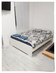 een bed in een kamer met een witte muur bij SouvenirAppart Sienkiewicza in Bydgoszcz