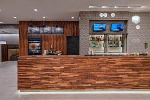 a bar in a hotel with a wooden counter at Courtyard by Marriott Houston Sugar Land/Lake Pointe in Sugar Land
