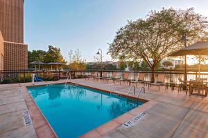 a swimming pool with tables and chairs on a patio at Courtyard by Marriott Houston Sugar Land/Lake Pointe in Sugar Land