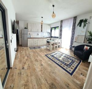 a kitchen and living room with a wooden floor at Apartament Eminescu in Zărneşti