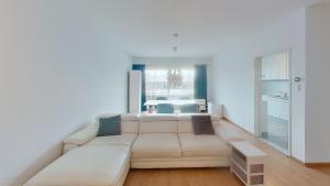 nice and cosy apartment في إيديخم: غرفة معيشة مع أريكة بيضاء وطاولة