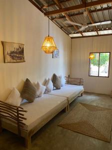 Cette chambre comprend deux lits et un lustre. dans l'établissement Kirãmam Villa, à Pasikuda