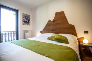 een slaapkamer met een groot bed met een houten hoofdeinde bij La Rosa delle Alpi Luxury Apartment in Chamois