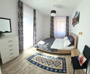 a bedroom with a bed and a tv in a room at Apartament Eminescu in Zărneşti