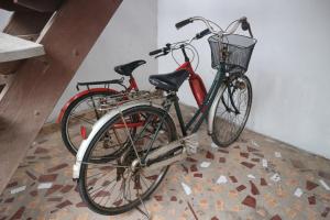 Dos bicicletas están estacionadas junto a una pared. en บ้านน่านโฮมสเตย์, en Nan