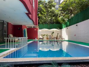 a swimming pool with chairs and umbrellas on a building at Twin Apart Hotel in Alanya