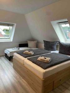 two twin beds in a room with two windows at Holländer Flair Friedrichstadt in Friedrichstadt