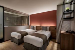 a room with two beds in a room with at Muzik Hotel - Ximen Station Branch in Taipei