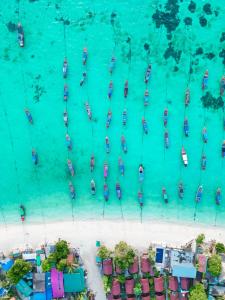una vista aerea di un gruppo di imbarcazioni in acqua di Lipe Power Beach Resort a Koh Lipe