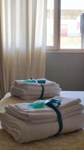 tre asciugamani pieghevoli seduti su un tavolo con finestra di Casa Vacanze Feudo Gipponeri a Montevago