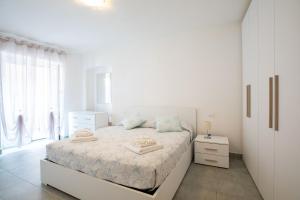 a white bedroom with a bed and a window at Casa Adriana in Riomaggiore
