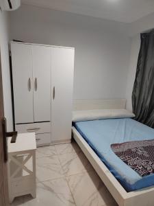 a bedroom with a bed and a white cabinet at Porto golf marina ,2 bedrooms , Families only in El Alamein