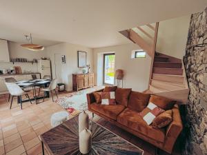 un soggiorno con divano marrone e tavolo di Domaine du Mimosa a Perros-Guirec