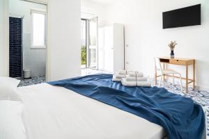 聖塔·馬里亞·迪·卡斯特的住宿－Marea b&b，一间卧室配有一张带蓝色床单的床和一张书桌。