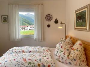 a bedroom with a bed and a window at TYROL PURElife Lodges in Sankt Jakob in Defereggen