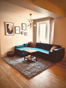 a living room with a blue couch and a table at Magnificent Modern Apartment Central Oslo in Oslo