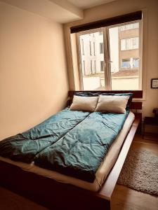a bed sitting in a room with a window at Magnificent Modern Apartment Central Oslo in Oslo