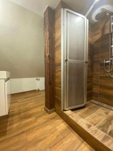 baño con nevera y suelo de madera. en Apartmán Prachatice en Prachatice