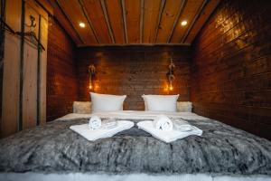 a bedroom with a bed with towels on it at Hotel & Spa Resort Järvisydän in Rantasalmi