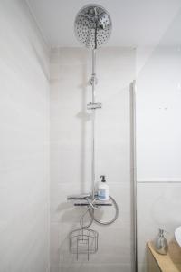 La salle de bains blanche est pourvue d'une douche et d'un lavabo. dans l'établissement Moderno estudio-loft Chamartín, à Madrid