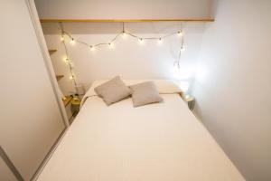 - une petite chambre avec un lit éclairé dans l'établissement Moderno estudio-loft Chamartín, à Madrid