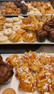 a display of different types of donuts and pastries on trays at Grand Universe Lucca, Autograph Collection in Lucca