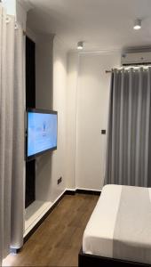 una camera con letto e TV a schermo piatto di Dreams Hotel Zanzibar a Zanzibar City