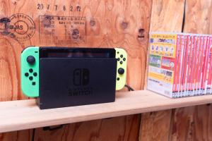 Un controlador de videojuego en un estante junto a libros. en Vacation"Ninja"house Secretbase near Asakusa, en Tokio