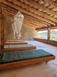 a row of beds in a room with wooden ceilings at Ca n'Heras in Canet de Adri