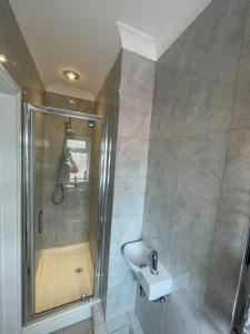 ein Bad mit einer Dusche und einem Waschbecken in der Unterkunft Luxury 2 bedroom maisonette with private garden, fibre WIFI, Sky channels in Camberley