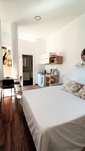a bedroom with a white bed and a kitchen at Villacarmen Suite in Benalmádena