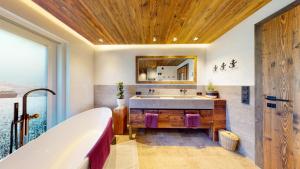 a bathroom with a tub and a sink at PitzPlus Appartements in Sankt Leonhard im Pitztal