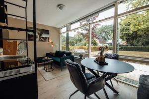 cocina y sala de estar con mesa y sillas en Zoo apartment en Emmen