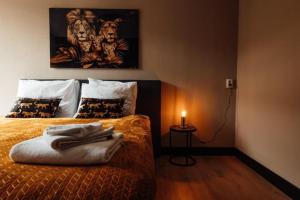 Un dormitorio con una cama con una vela. en Zoo apartment, en Emmen