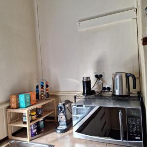 a kitchen with a microwave and a coffee maker on top of it at May Queen Forest Cottage Manjimup in Deeside