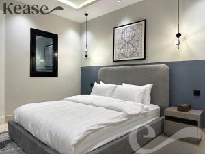 1 dormitorio con 1 cama blanca grande y espejo en Kease Malqa B-4 Royal Touch AZ31 en Riad