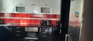 eine rot-weiße Küche mit einem Herd und einer Mikrowelle in der Unterkunft VILA LUXURY 