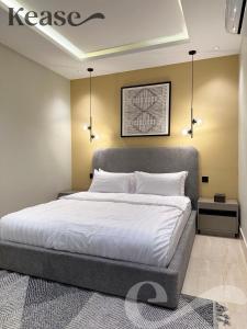 a bedroom with a large bed with white sheets at Kease Malqa B-4 Royal Touch AZ31 in Riyadh