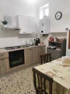 Sicignano degli Alburni的住宿－B&B Zì Camillo，厨房配有白色橱柜和桌椅