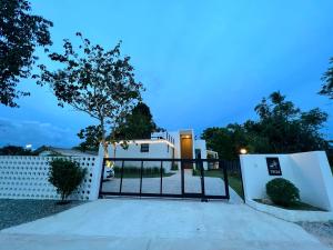 a gate in front of a white fence at 168 Garden Pool Villa in Nong Prue