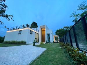 a large white house with a walkway at 168 Garden Pool Villa in Nong Prue