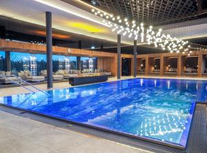 a large blue swimming pool in a hotel lobby at Wellness & Naturresort Reischlhof in Wegscheid