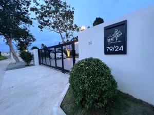 a sign on the side of a building with a gate at 168 Garden Pool Villa in Nong Prue