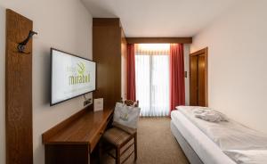 カンポ・トゥーレスにあるHotel Mirabellのベッド、デスク、ベッドが備わるホテルルームです。