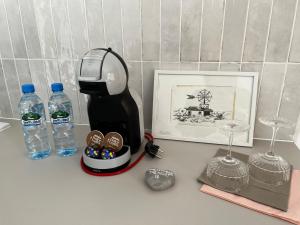una macchinetta del caffè e una bottiglia d'acqua su un bancone di marga_apt a Świnoujście