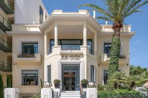 a building with a palm tree in front of it at Avra City Boutique Hotel in Chania