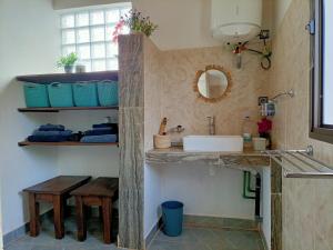 uma casa de banho com um lavatório, um espelho e um balcão em Maison d'hôtes Akany Fifaliana em Antananarivo