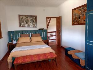 a bedroom with a bed with a blue headboard at Maison d'hôtes Akany Fifaliana in Antananarivo
