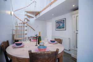 a dining room table with chairs and a bottle of wine at Melbourne Cottage - 3 Bedroom Cottage - Pembroke in Pembroke