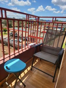 a chair on a balcony with a view of a parking lot at G&G Homes WESTINDIES in Eldoret